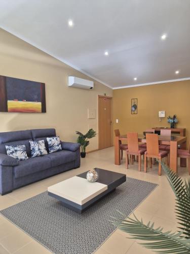 a living room with a blue couch and a table at Serra & Mar in Vila Franca do Campo