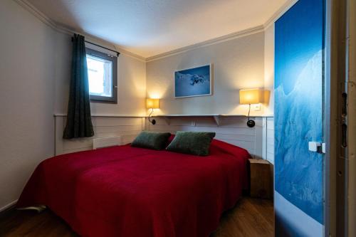 - une chambre avec un lit rouge et 2 oreillers verts dans l'établissement Chalet Chamois - 4 Pièces pour 6 Personnes MAE-1081, à Val Thorens