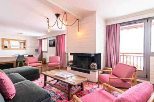 - un salon avec des chaises roses et une cheminée dans l'établissement Chalet Chamois - EN COURS DE RENOVATION MAE-6331, à Val Thorens