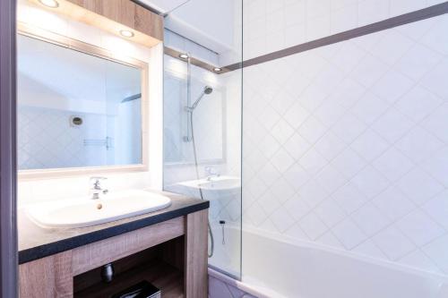 une salle de bain blanche avec un lavabo et une douche dans l'établissement Chalet Chamois - EN COURS DE RENOVATION MAE-6331, à Val Thorens