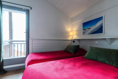 une chambre avec un lit rouge et une grande fenêtre dans l'établissement Chalet Chamois - EN COMPLETE RENOVATION MAE-6351, à Val Thorens
