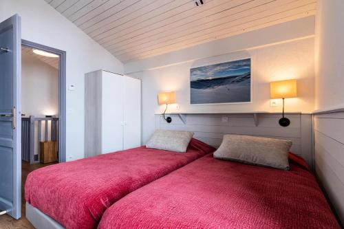 une chambre avec un lit avec une couverture rouge dans l'établissement Chalet Chamois - EN COURS DE RENOVATION MAE-6341, à Val Thorens