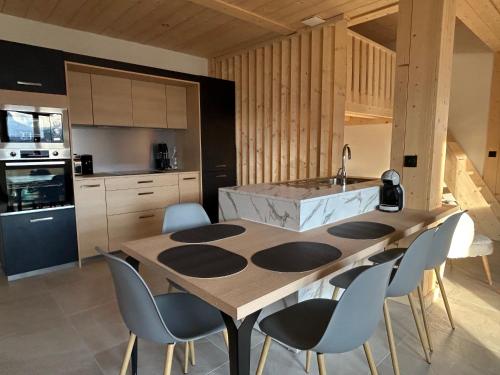 une cuisine avec une grande table et des chaises en bois dans l'établissement Appartement Dolce Vista, à Passy