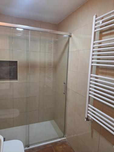a shower with a glass door in a bathroom at La Escondida in Burgohondo