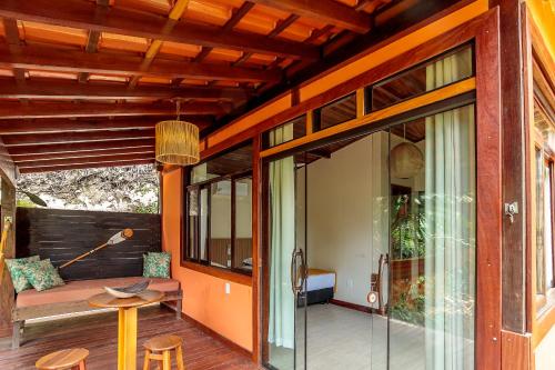 a patio with a couch and a table on a porch at Pousada Lagamar in Praia Vermelha