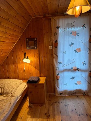 a bedroom with a bed and a curtain with fish on it at Górski domek w Szczyrku in Szczyrk