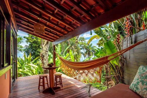 a hammock on the porch of a house at Pousada Lagamar in Praia Vermelha