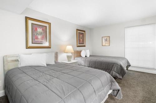 a bedroom with two beds and a window at Golf Side Elegance 2BR Villa Hideaway in Pawleys Island