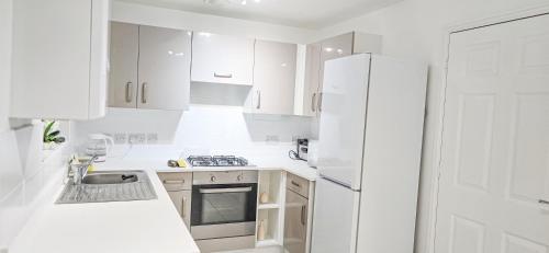 a kitchen with white cabinets and a white refrigerator at Luxury Room 8min to Sheffield City Center, Free parking in Manor