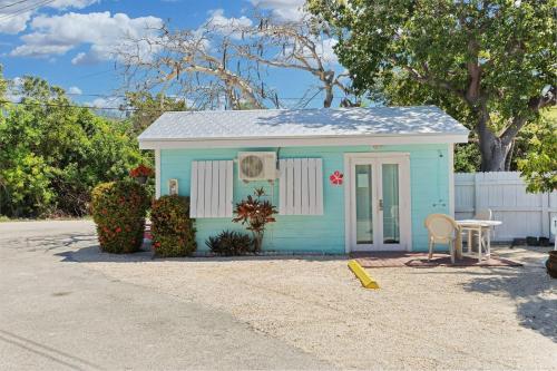 a small blue shed with a table and a chair at Tropical Cottages in Marathon
