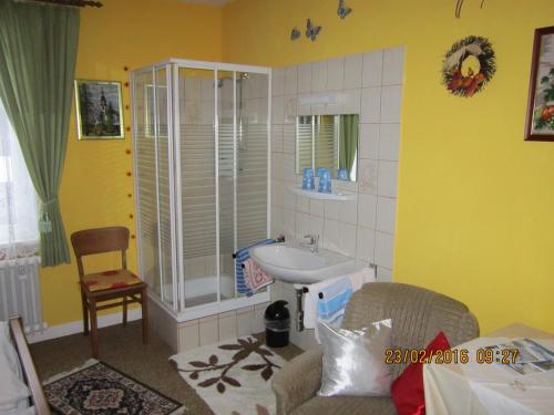 ein Bad mit einem Waschbecken und einer Dusche in der Unterkunft Pension Haus zur Orke in Winterberg
