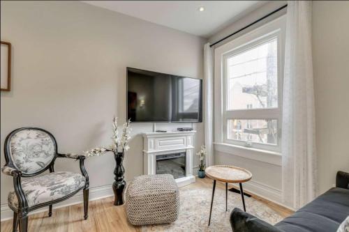 a living room with a couch and a tv at Casa Queen - Unique 2BR Suite in Leslieville in Toronto