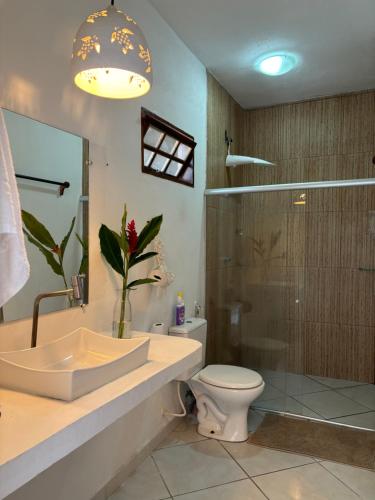 a bathroom with a sink and a toilet and a shower at Casa Mathia in Caraíva