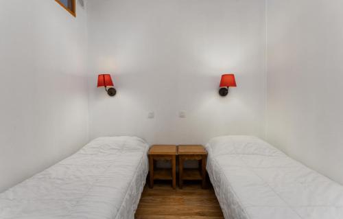 - 2 lits dans une chambre avec une table et 2 lampes dans l'établissement Résidence Les Hauts De Preclaux - Charmant studio avec vue sur les pistes MAE-2361, aux Orres