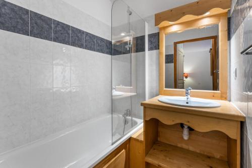 une salle de bain avec un lavabo, une baignoire et un miroir dans l'établissement Résidence Les Hauts De Preclaux - Charmant studio avec vue sur les pistes MAE-2361, aux Orres