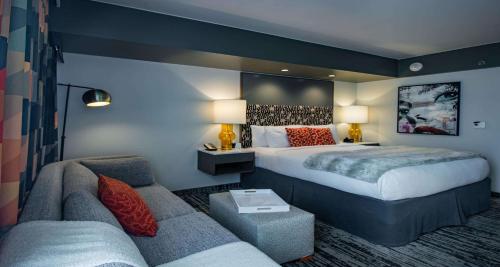 a hotel room with a bed and a couch at Hotel Eastlund - Best Western Premier Collection in Portland