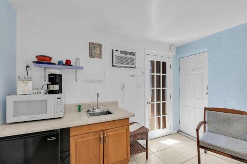 a kitchen with a sink and a microwave at Tropical Cottages in Marathon