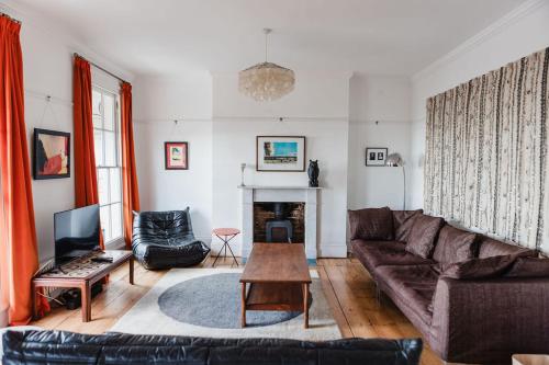 a living room with a couch and a table at Beautiful Beachfront Townhouse in St. Leonards