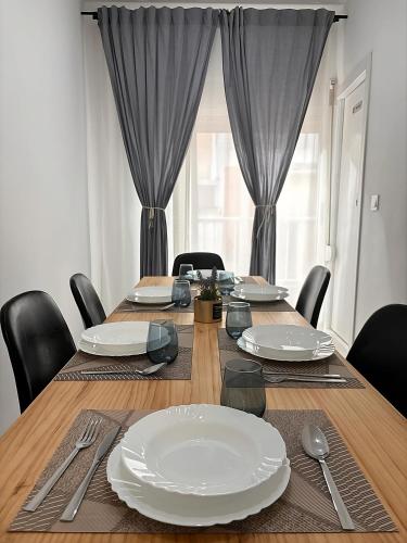 a dining room table with plates and silverware on it at Apartamento Sofía II a 500m de la playa in Puerto de Sagunto