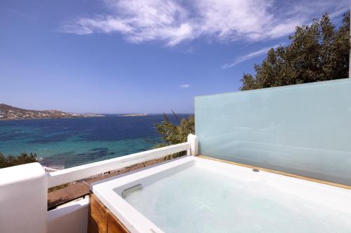a bath tub with a view of the ocean at Legacy Suites in Mýkonos City
