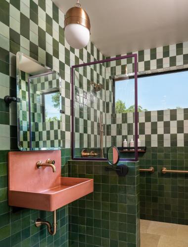 a bathroom with a pink sink and green tiles at The Leona in Lockhart