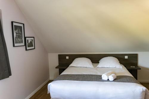 a bedroom with a bed with two white pillows at Hôtel restaurant La Grand Mare in Conches-en-Ouche