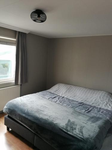 a bedroom with a bed and a light at Maison Louise in Sint Annaland
