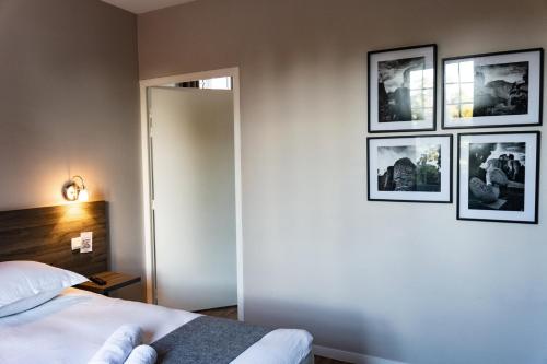 a bedroom with four pictures on the wall at Hôtel restaurant La Grand Mare in Conches-en-Ouche