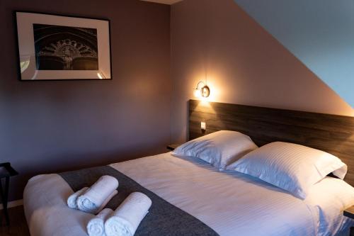 a bedroom with a bed with white towels on it at Hôtel restaurant La Grand Mare in Conches-en-Ouche