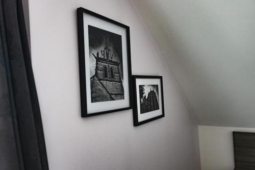 three framed pictures on a white wall at Hôtel restaurant La Grand Mare in Conches-en-Ouche
