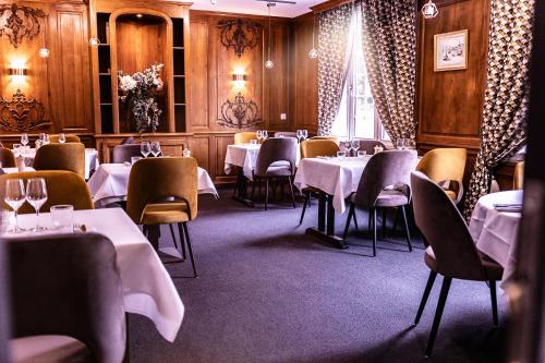 a restaurant with tables and chairs in a room at Hôtel restaurant La Grand Mare in Conches-en-Ouche