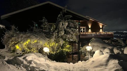 a house covered in snow at night with lights at Fairy tale house during Ski world cup in Melhus
