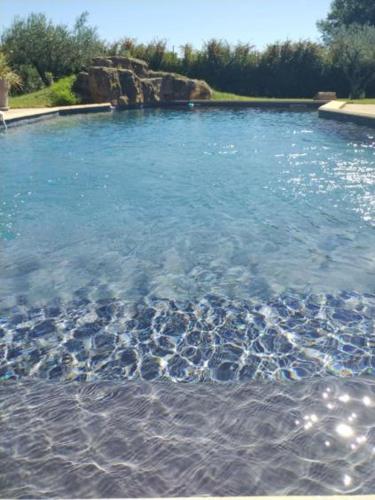 a pool of blue water with rocks in it at Mas de l'Olivier - Enclave des Papes - Visan - 8 couchages in Visan
