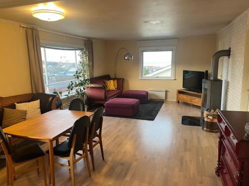 a living room with a table and a couch at Cozy home with a fireplace, well connected to bus, quiet and view over the fjord in Trondheim