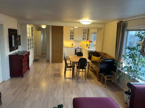 a kitchen and dining room with a table and chairs at Cozy home with a fireplace, well connected to bus, quiet and view over the fjord in Trondheim