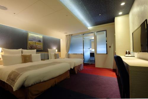 a hotel room with two beds and a flat screen tv at V-one Vogue Hotel in Taipei