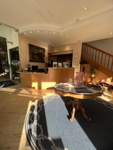 a living room with a wooden table and a rug at Les Reflets Jaunes in Givet