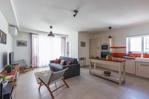 a living room with a couch and a table at Central 2BR, sunny terrace and top location close to Beach in Is-Swieqi