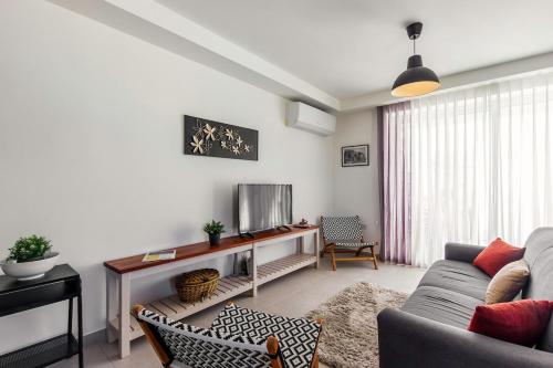 a living room with a couch and a tv at Central 2BR, sunny terrace and top location close to Beach in Is-Swieqi