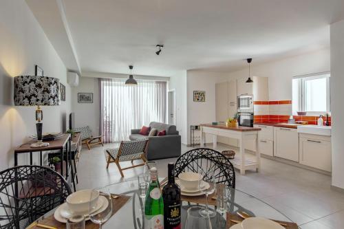 a kitchen and living room with a table and chairs at Central 2BR, sunny terrace and top location close to Beach in Is-Swieqi