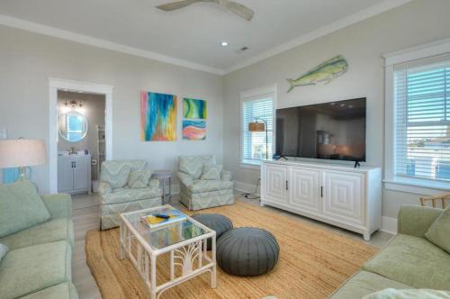 a living room with a couch and a tv at Aloweha in Oak Island