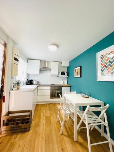 une cuisine avec une table et des chaises dans une pièce dans l'établissement Triplex à Plailly Parc Asterix CDG Villepinte, à Plailly