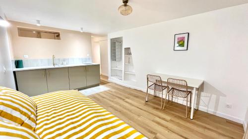 un salon avec un lit, une table et des chaises dans l'établissement Charming Bright Studio in Ménilmontant, à Paris