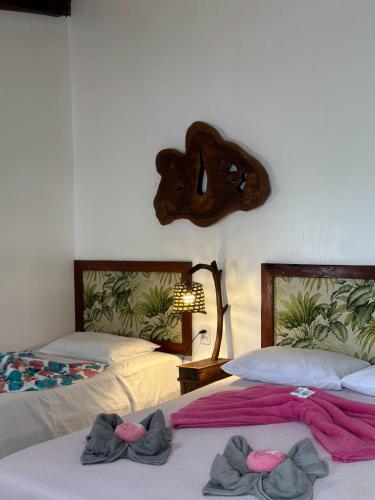 two beds in a room with towels on them at Espaço Sairé - 8 minutos da Praia in Alter do Chao