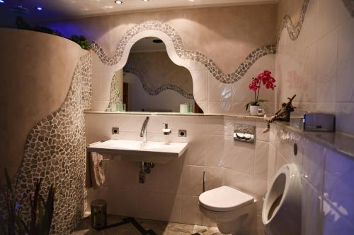 a bathroom with a sink and a toilet and a mirror at HTS Haus Respirada Wellnessarea, Whirlpool, GYM, Sauna in Meckenheim