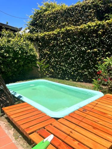 a small swimming pool sitting on a wooden table at Acogedora casa cerca de la Laguna, con pileta in Chascomús