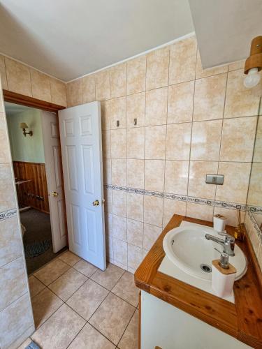 a bathroom with a sink and a mirror at Departamento en Pucón - Camino al Volcan in Pucón