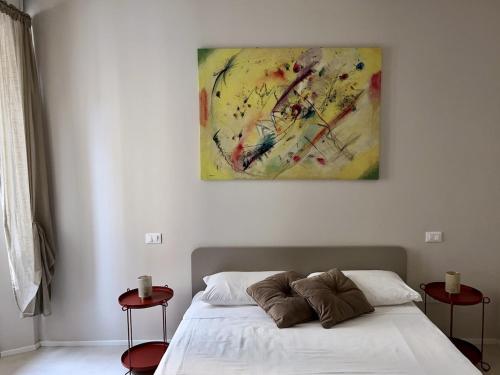 San Martino Suite - Pavia City - by HOST4U في بافيا: غرفة نوم بها سرير ولوحة على الحائط