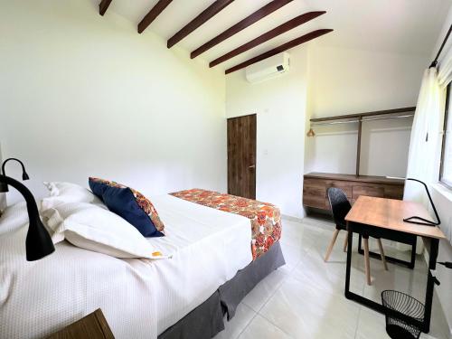 a bedroom with a bed and a desk and a table at Doral House Villavicencio in Villavicencio