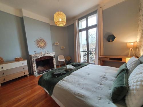- une chambre avec un grand lit et une cheminée dans l'établissement VUE EXCEPTIONNELLE sur la CATHÉDRALE, haut standing et garage privé, à Reims